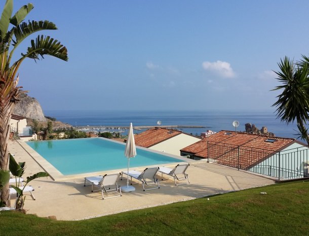 residence-magara-cefalu-sicilie-zwembad-ligstoelen-palmbomen.jpg